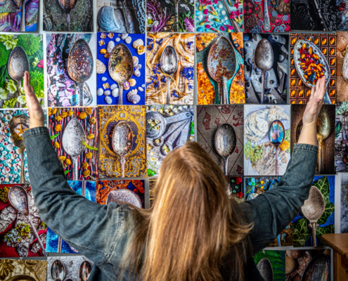 Donna Dufault in front of a wall of her worn spoon photographs